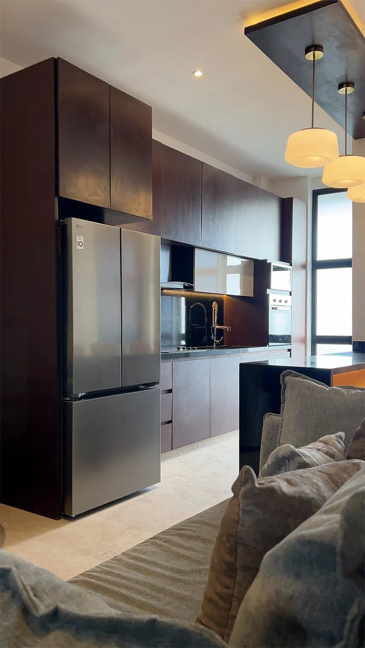 Cocina y sala con acabados en madera oscura