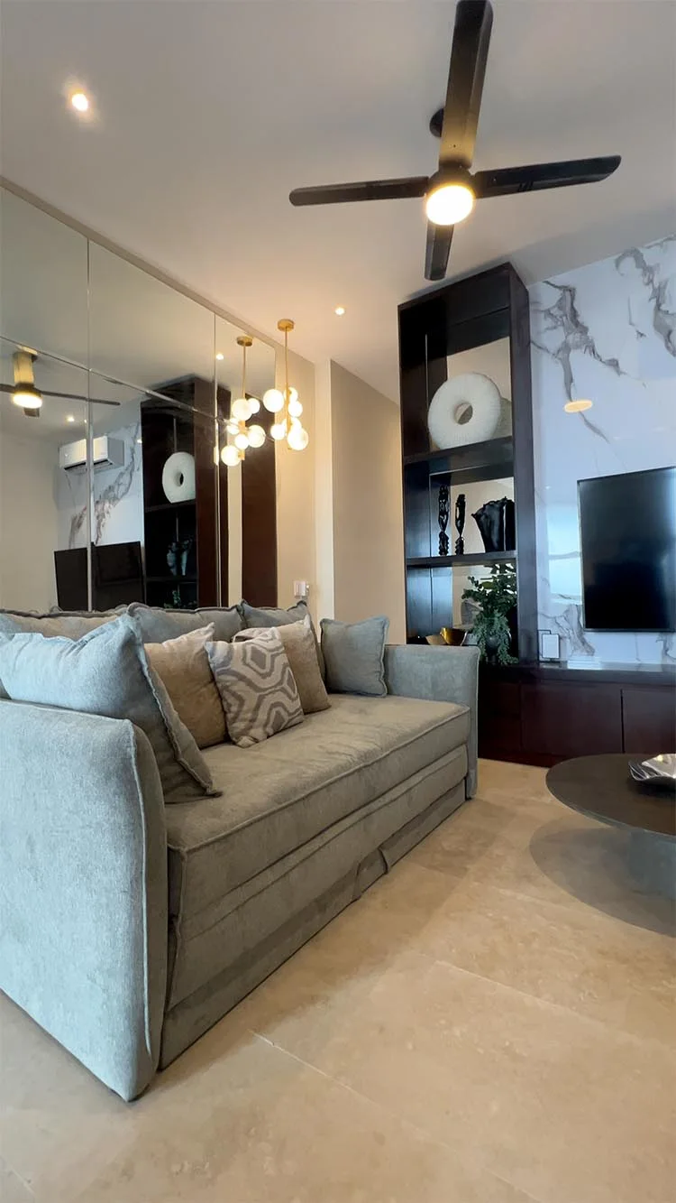 Sala de estar con sofá gris y espejos
